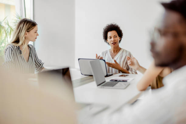 istock Female Manager having a Meeting eith Her Team in a Corporate Office 1421968694