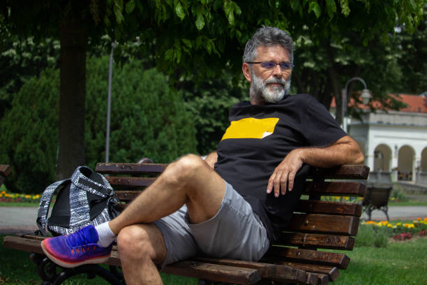 istock Senior man enjoy on bench in public park 1421971718