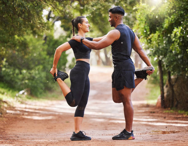 jeune couple en forme qui fait de l’exercice à l’extérieur ensemble, se lie tout en s’étirant et se prépare pour un entraînement cardio. petite amie et petit ami athlétiques affectueux tout en s’entraînant et en restant en bonne santé - staying fit photos et images de collection