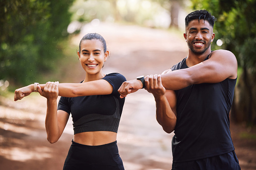 Fit, active and athletic couple stretching, getting ready and preparing for workout, exercise and training. Portrait of smiling, sporty and healthy man and woman in eco nature park, forest and garden