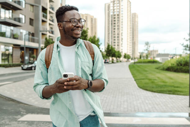 istock African-American young man using smart phone on the street 1421982908