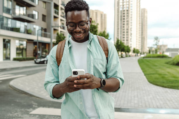 istock African-American young man using smart phone on the street 1421982909