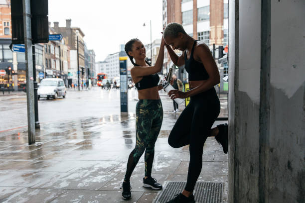 Sportswomen running in the city streets under the rain.