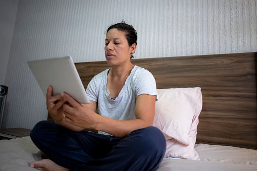 woman in bed using digital tablet