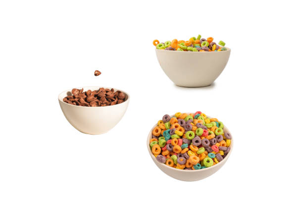 istock Chocolate corn flakes falling to the white bowl isolated on white. Motion. 1421985210