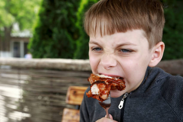 istock Kid eating grilled chicken wings 1421987268