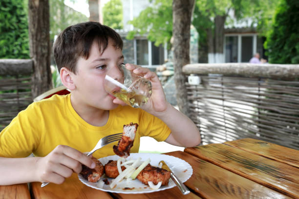 Boy eating pork neck kebab on restaurant terrace
