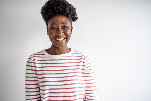 Young African American woman with short hair in front of the white wall