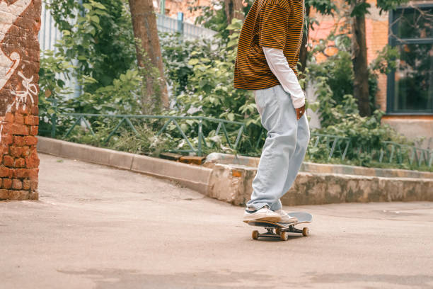 porträt eines jungen, gutaussehenden, stilvollen schwarzen mannes mit natürlichen haar-afro-dreadlocks. afroamerikanischer typ. treppe, mit graffiti bemalte wand im armen viertel des stadtviertels street art culture. afroamerikaner skateboarder mann. mil - graffiti men wall street art stock-fotos und bilder