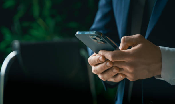 istock Businessman in suit with mobile phone in hands. Man typing message, using social net. Checking news. Making business meeting. Modern office.General manager,ceo.Calling to partner.Planning working day 1421994534