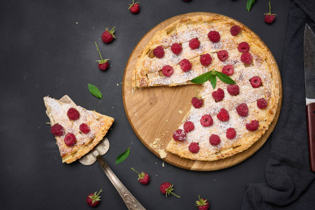 istock Round baked pie with apples and sprinkled with powdered sugar on a black table. 1421995887