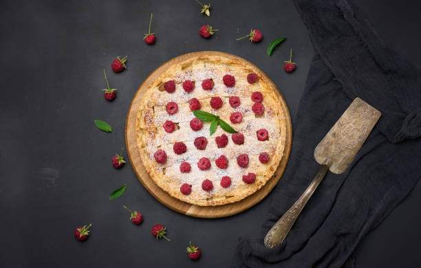 istock Round baked pie with apples and sprinkled with powdered sugar on a black table. 1421996056