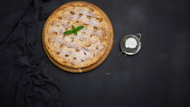 istock Round baked apple pie on a black table. View from above 1421996868