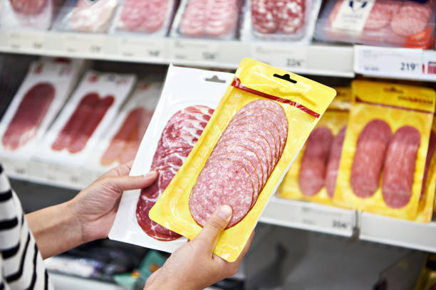 istock Woman chooses sausage at store 1421999304