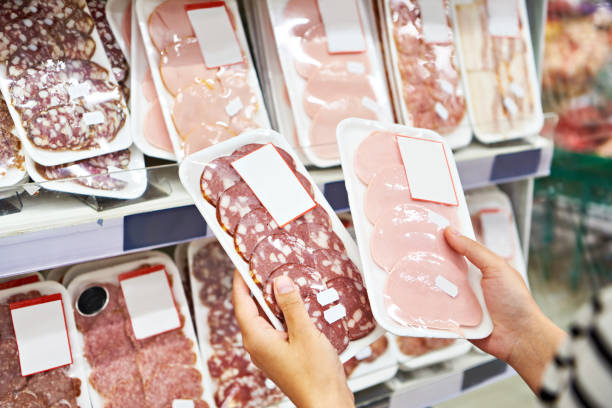 여자는 가게에서 소시지를 선택합니다. - supermarket meat women packaging 뉴스 사진 이미지