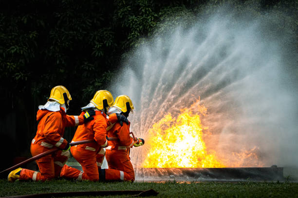 istock Firefighter Concept. Fireman using water and extinguisher to fighting with fire flame. firefighters fighting a fire with a hose and water during a firefighting training exercise 1422003187