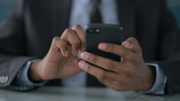 istock Hands of African Businessman using Smartphone 1422006606