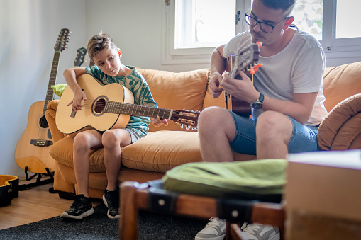 Boy practicing guitar in music school