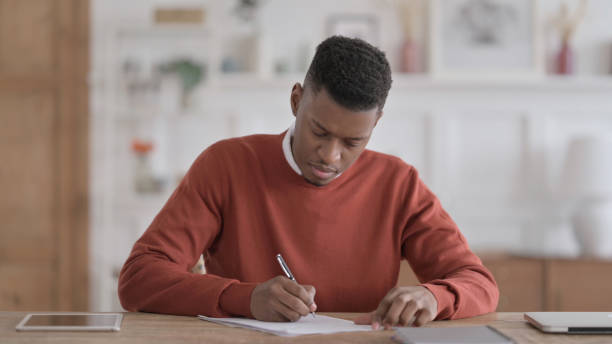 istock African Man Writing on Paper in Office 1422020836
