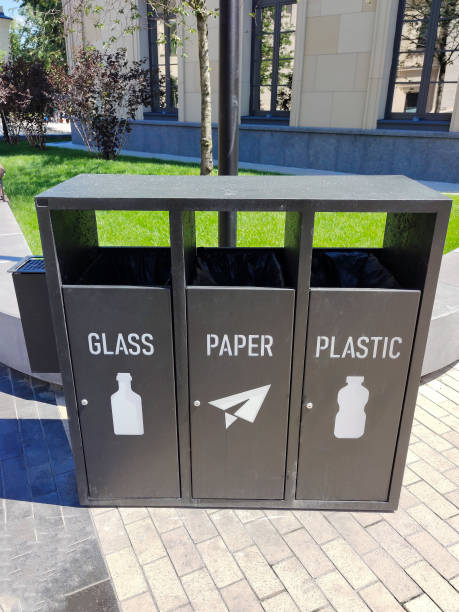 istock Sorting garbage bins on the street, which are divided into GLASS, PAPER and PLASTIC with the corresponding logo 1422022816