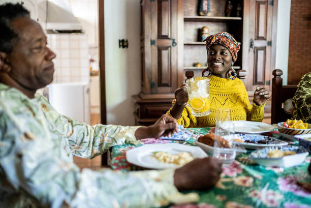istock Young woman serving juice during lunch at home 1422024268