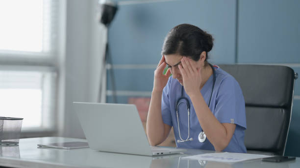 istock Indian Female Doctor having Headache while Working on Laptop 1422026032