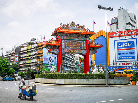 Bangkok, Thailand - September 10, 2019: Gate of Chinatown in Bangkok, seated at traffic circle and roundabout of Yaowarat Road. street vendor in front, at the background are banners at buildings.