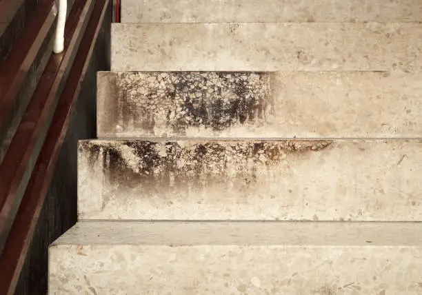 Composite stone stairs steps dirty and heavy signs of temperature. Selective focus.