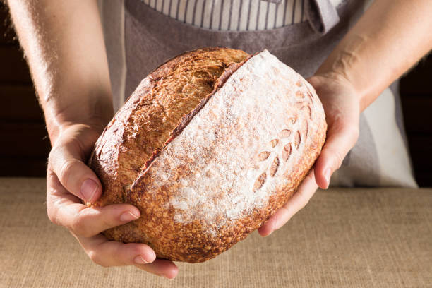 istock woman's hands holding a homemade bread 1422030432