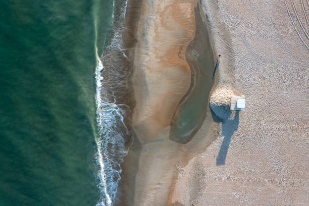 vista aérea de cima para baixo da praia e do oceano com um solitário suporte de salva-vidas vazio - beach kiosk above - fotografias e filmes do acervo