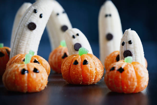 istock Halloween cute pumpkin orange fruit with scary banana ghosts 1422035443