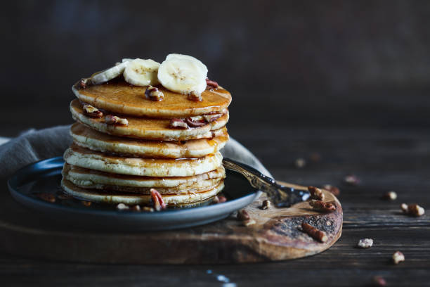 istock Maple syrup pouring onto pancakes against dark background 1422036646