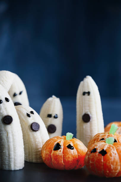 istock Tangerine Jack O Lanterns with Ghost Bananas 1422038193