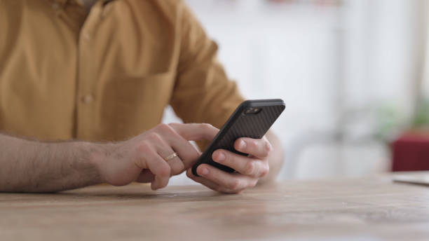 istock Hands Close up of Young Man using Smartphone 1422039574