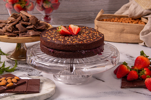 Chocolate cake with walnuts decorated with strawberries, healthy ketogenic diet for breakfast or birthday celebration