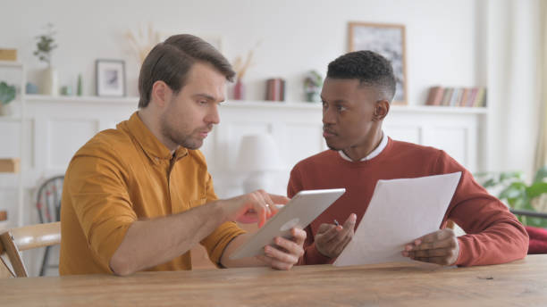 istock African Man and Young Man Working with Tablet and Documents 1422048566