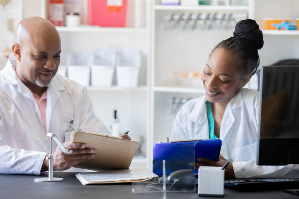 istock Two pharmacists discussing their sales reports. 1422055743