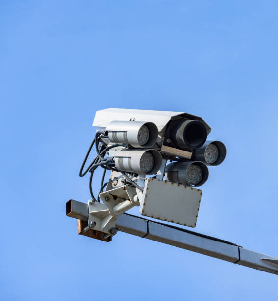 cctv, überwachungskamera für die verkehrskontrolle auf der straße am blauen himmel - vertical security camera security system security stock-fotos und bilder