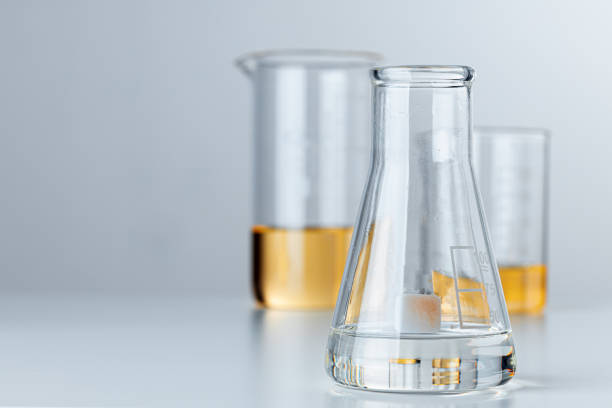 istock Laboratory glassware with yellow oily liquid on grey background 1422063468