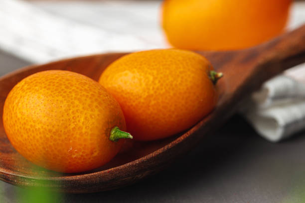 Heap of kumquat fruit on kitchen table close up