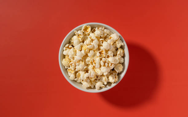 istock Popcorn in a white bowl placed on a red background. 1422066812