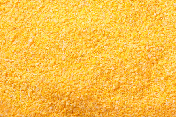 Raw cornmeal flour texture used in polenta on isolated background. top view