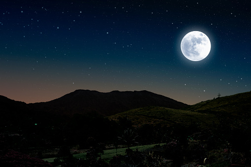 Starry night over mountain with full moon. Beautiful rural night landscape