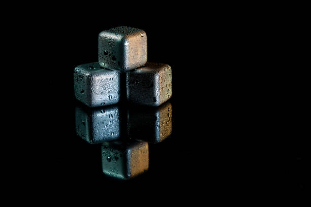 istock Stainless steel cubes simulating ice for cooling drinks on a black surface with a reflection. 1422071369