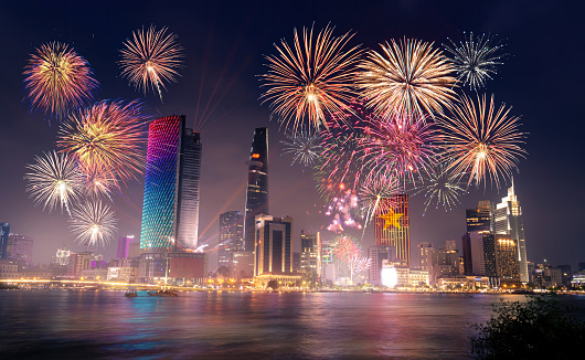 Celebration. Skyline with fireworks light up sky over business district in Ho Chi Minh City ( Saigon ), Vietnam. Beautiful night view cityscape. Holidays, independence day, New Year and Tet holiday