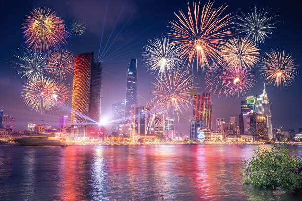 celebration. skyline with fireworks light up sky over business district in ho chi minh city ( saigon ), vietnam. beautiful night view cityscape. holidays, independence day, new year and tet holiday - laser firework display performance showing imagens e fotografias de stock