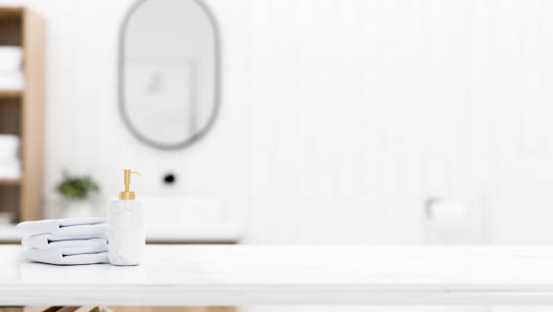 istock White marble tabletop with towels, shampoo bottle and empty mockup space over blurred bathroom 1422084459