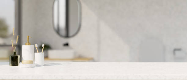 istock White bathroom tabletop with bath accessories set and copy space over blurred bathroom background 1422084460
