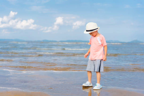 A baby playing with water by the sea