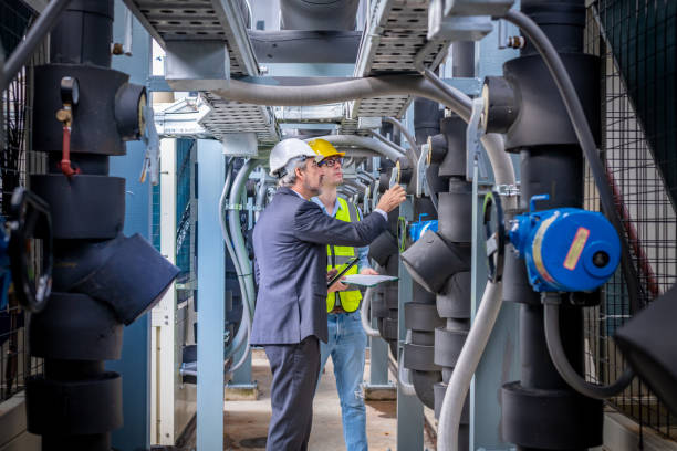 istock engineer under checking the industry cooling tower air conditioner is water cooling tower air chiller HVAC of large industrial building to control air system. 1422088824
